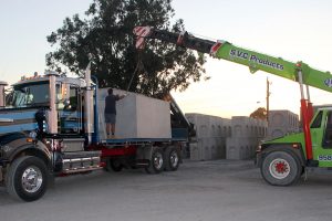 SVC crane lifting a large precast concrete pit onto a delivery truck.